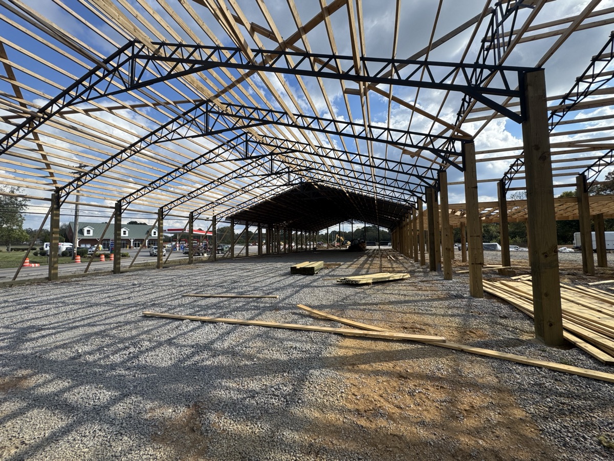 Wide exterior view of Thompsons Station Hardware construction in Franklin, TN, showing the full wooden and steel framing structure of the large building.